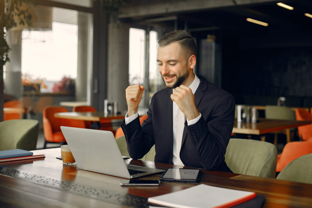 Handsome man in a black suit. Businessman working in a cafe